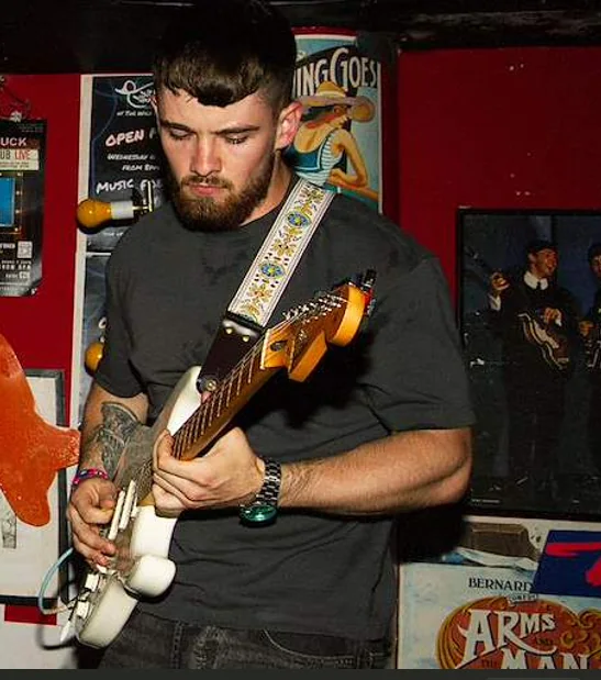 Dublin guitar teacher Ben Crosbie playing electric guitar live on stage